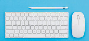 #PraCegoVer #PraTodosVerem – descrição: foto de um teclado, um mouse e um lápis sobre uma mesa azul.
